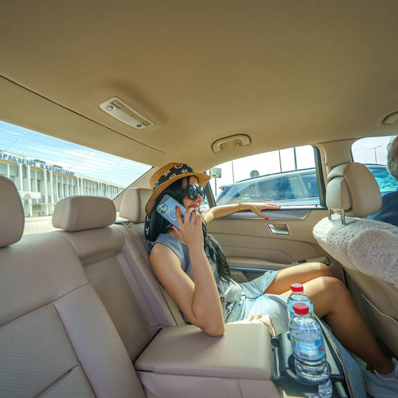 Passenger relaxing in the back seat talking on the phone during a comfortable airport taxi transfer
